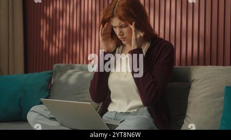 Femme caucasienne freelancer femme d'affaires ordinateur portable en ligne travaillant à la maison épuisé fatigué surtravaillé a stressé fille malheureuse tenir la tête Banque D'Images