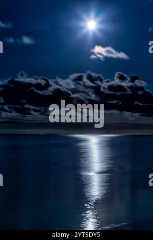 La pleine lune se reflète la nuit dans la mer des Wadden au large de l'île de Juist en Frise orientale, en Allemagne. Banque D'Images