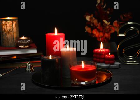 Belles bougies allumées et décor sur la table noire Banque D'Images