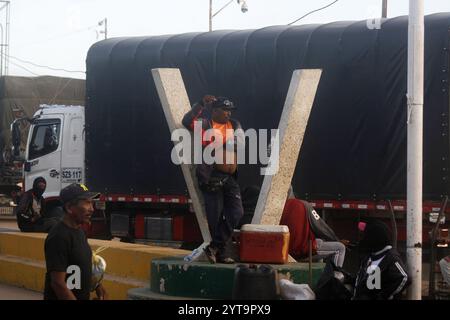 Venezuela-Paraguachón-6-12-2024. Un chauffeur d’une unité de transport lourd attend à l’extérieur de son véhicule l’ouverture, pour passer avec sa charge vers la frontière ce vendredi 6 décembre, dans le secteur de la Raya à Paraguachón, dans l’état de Zulia, Venezuela. Les nouvelles mesures de sécurité ordonnées par le président Nicolás Maduro au poste de contrôle de la Garde nationale bolivarienne (GNB) à Paraguachón, situé à huit kilomètres de la frontière entre le Venezuela et la Colombie, ont pour objectif principal d'accroître la sécurité et de « faire progresser la lutte contre la contrebande et la violence dans la zone frontalière ». (Photo de Humberto Matheus/Sipa U Banque D'Images