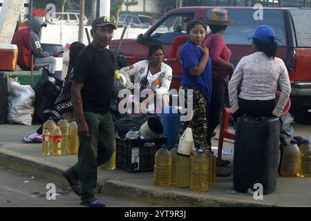 Venezuela-Paraguachón-6-12-2024. Les gens vendent de l'essence colombienne de contrebande, à trente mètres du poste de contrôle de la Garde nationale bolivarienne (GNB), ce vendredi 6 décembre, dans le secteur de la Raya à Paraguachón, dans l'État de Zulia, Venezuela. Les nouvelles mesures de sécurité ordonnées par le président Nicolás Maduro au poste de contrôle de Paraguachón, situé à huit kilomètres de la frontière entre le Venezuela et la Colombie, visent à renforcer la sécurité et à « progresser dans la lutte contre la contrebande et la violence dans la zone frontalière ». (Photo Humberto Matheus/Sipa USA) Banque D'Images