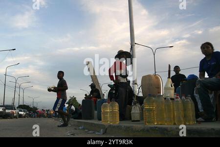 Venezuela-Paraguachón-6-12-2024. Les gens vendent de l'essence colombienne de contrebande, à trente mètres du poste de contrôle de la Garde nationale bolivarienne (GNB), ce vendredi 6 décembre, dans le secteur de la Raya à Paraguachón, dans l'État de Zulia, Venezuela. Les nouvelles mesures de sécurité ordonnées par le président Nicolás Maduro au poste de contrôle de Paraguachón, situé à huit kilomètres de la frontière entre le Venezuela et la Colombie, visent à renforcer la sécurité et à « progresser dans la lutte contre la contrebande et la violence dans la zone frontalière ». (Photo Humberto Matheus/Sipa USA) Banque D'Images