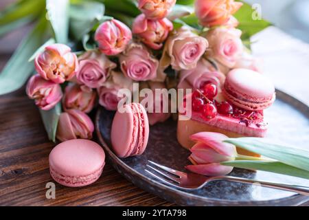 Belles roses roses et tulipes avec des pâtes douces. Fond de concept pour la fête des mères, la saint-valentin et les mariages. Gros plan avec une faible profondeur de champ. Banque D'Images