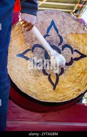 Main avec maillet frappant un tambour avec un motif de fleur lors d'un événement Têt (nouvel an lunaire). Têt est la célébration la plus importante dans la culture vietnamienne. Banque D'Images