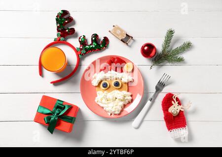 Assiette avec crêpe en forme de Père Noël sur fond en bois blanc Banque D'Images