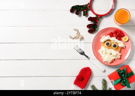 Assiette avec crêpe en forme de Père Noël sur fond en bois blanc Banque D'Images