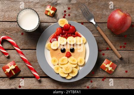 Assiette avec crêpe en forme de Père Noël sur fond en bois Banque D'Images