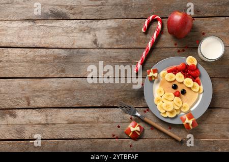 Assiette avec crêpe en forme de Père Noël sur fond en bois Banque D'Images