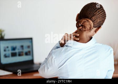 Affaires, femme et ordinateur portable avec douleur au cou dans le bureau pour burnout, surmenagé et fatigue inconfortable. Dos, employé professionnel et mal de corps avec Banque D'Images