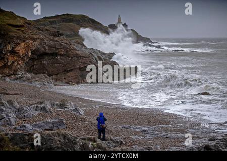 Swansea, Royaume-Uni. 07 décembre 2024. Un homme prend une photo des vagues qui se jettent sur le phare et le promontoire de Mumbles ce matin alors que la tempête Darragh continue de frapper le Royaume-Uni. Crédit : Phil Rees/Stockimo/Alamy Live News Banque D'Images