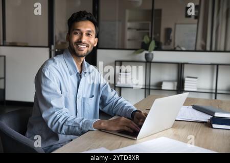 Homme d'affaires est assis au bureau du lieu de travail avec ordinateur portable, portrait de bureau Banque D'Images