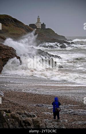 Swansea, Royaume-Uni. 07 décembre 2024. Un homme prend une photo des vagues qui se jettent sur le phare et le promontoire de Mumbles ce matin alors que la tempête Darragh continue de frapper le Royaume-Uni. Crédit : Phil Rees/Stockimo/Alamy Live News Banque D'Images