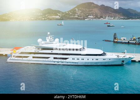 Un yacht de luxe amarré dans les eaux claires des Caraïbes avec des collines pittoresques en arrière-plan Banque D'Images