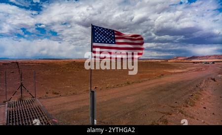 MARS 2024, TONALEA ARIZONA - Navajo Tribal Highway, drapeau américain déchiré vole au-dessus d'un ranch isolé du désert Banque D'Images
