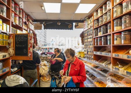 Athènes, Attique - GR - Oct 25, 2024 les acheteurs parcourent un magasin d'épices aromatiques près du marché Varvakios, entouré d'étagères d'épices colorées, d'herbes, et Banque D'Images