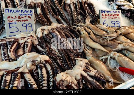 Athènes, Attique - GR - 25 octobre 2024 pieuvre et calmars au marché central de Varvakios : tentacules frais et céphalopodes entiers exposés sur la glace, avec du handwri Banque D'Images