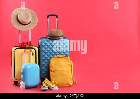 Voyage à l'étranger. Valises, sac à dos, chapeaux et chaussures sur fond rouge. Espace pour le texte Banque D'Images