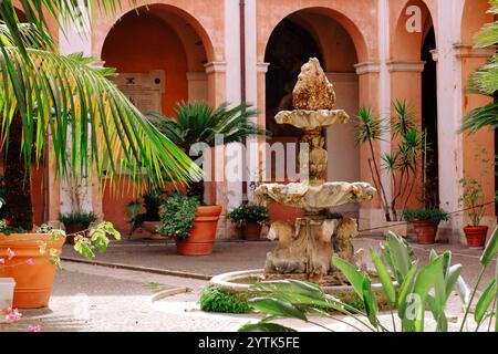 Fontaine et palmiers dans une cour italienne Banque D'Images