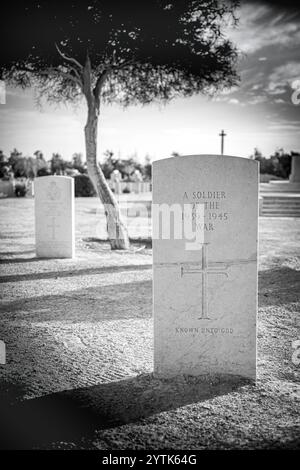 Photographie solennelle en noir et blanc d'une pierre tombale inscrite « Un soldat de la guerre de 1939-1945, connu de Dieu » au cimetière de guerre d'El Alamein. Banque D'Images