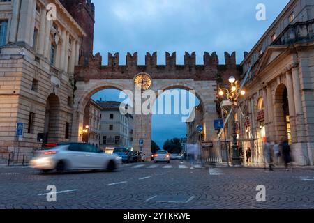 VÉRONE, ITALIE - 25 OCTOBRE 2023 : remparts de la ville médiévale et horloge sur l'ancienne porte de la ville, connue sous le nom de Portoni della Bra. Heure du soir Banque D'Images