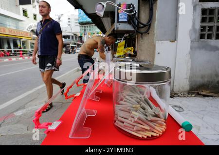 Pattaya, Thaïlande - 30 mai 2023 : Man vend des cigarettes de cannabis prêtes à fumer dans Walking Street, une rue piétonne touristique dans la ville de Pattaya. Banque D'Images