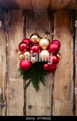 Couronne de Noël avec des ornements rouges et dorés sur fond de bois rustique. Photo de haute qualité Banque D'Images