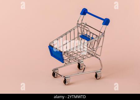 Chariot à provisions avec poignée bleue et panier bleu. Copier l'espace. Banque D'Images