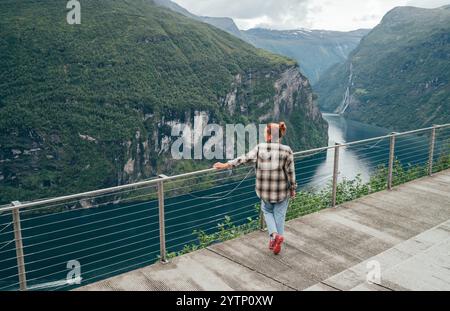 Jeune femme touriste jouissant d'une vue aérienne pittoresque de Geirangerfjord ou Geirangerfjorden fjord avec cascade de sept sœurs dans la région de Sunnmøre de Møre Banque D'Images