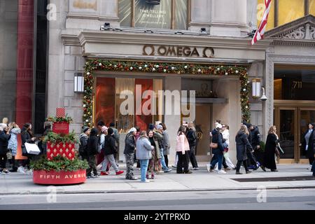 Les gens marchant le long de la 5ème Avenue ont passé le magasin Omnega le Black Friday, le début officiel de la saison des achats de vacances à New York. Banque D'Images