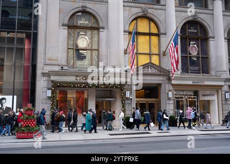 Les gens marchant le long de la 5ème Avenue ont passé le magasin Omnega le Black Friday, le début officiel de la saison des achats de vacances à New York. Banque D'Images