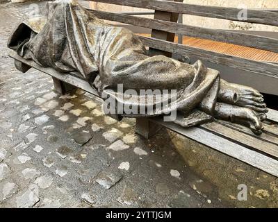 Sculpture en bronze de Jésus sans abri par Timothy Schmalz sur un banc de parc à Rome, Italie Banque D'Images