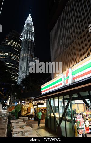 KUALA LUMPUR, MALAISIE - 08 NOVEMBRE 2023 : magasin 7-Eleven avec les tours Petronas en arrière-plan. 7-Eleven est une chaîne mondiale de magasins de proximité de Banque D'Images