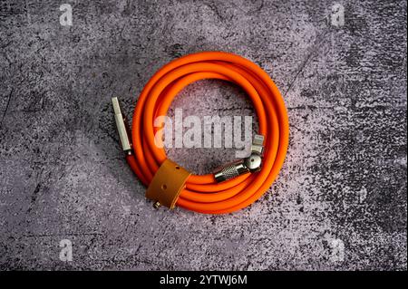 Câble USB type-C orange avec prise pivotante sur fond marbre. Câble de chargement pour iPhone. Photo de haute qualité Banque D'Images