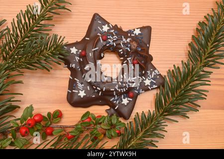 06.12.2024 Lebkuchen Deutschland/ Sachsen Anhalt/ Altmark/ Altmarkkreis Salzwedel/ Stadt Klötze/ Kusey/ Weihnachtsgebäck/ Gebäck/ Lebkuchenstern mit Schokoladenüberzug und Cremefüllung liegt auf einem Holztisch/ Tannenzweig und Vogelbeeren als Deko *** 06 12 2024 pain d'épice Allemagne Saxe Anhalt Altmark Altmarkkreis Salzwedel Stadt Klötze Kusey biscuits de Noël garnis et une étoile de Noël avec une branche de chocolat rowok Banque D'Images