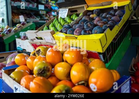 Une exposition de fruits comprenant des oranges, des pommes et des poires. Les oranges sont empilées haut dans une boîte Banque D'Images