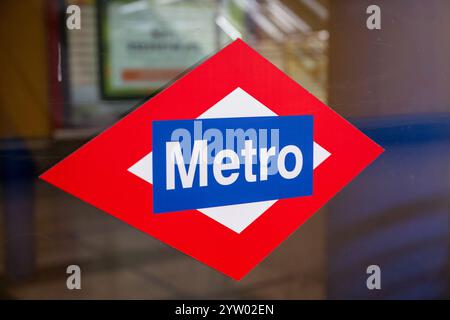 Un panneau rouge et bleu Metro est sur une fenêtre. Le signe est en forme de losange et le mot Metro est écrit en blanc Banque D'Images