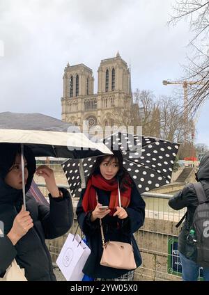 Paris, France. 08 décembre 2024. Les visiteurs regardent notre-Dame le jour de la réouverture de la célèbre cathédrale de Paris, en France, le dimanche 8 décembre 2024. La cathédrale médiévale a officiellement sonné ses cloches aujourd'hui pour la première fois en cinq ans après avoir brûlé dans un incendie dévastateur. Photo de Maya Vidon-White/UPI crédit : UPI/Alamy Live News Banque D'Images