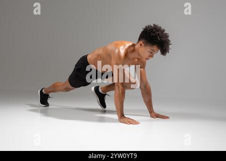 Jeune homme brésilien effectuant un exercice d'alpiniste à l'intérieur Banque D'Images