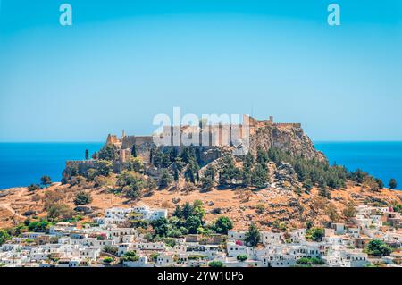 Le village de Lindos avec des maisons blanchies à la chaux et l'emblématique Acropole au sommet de la colline. Dans l'île de Rhodos, Dodécanèse, Grèce. Banque D'Images