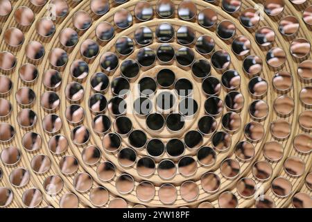 La photo présente une mosaïque artistique composée de miroirs ronds identiques disposés concentriquement autour d’un miroir central plus grand. Banque D'Images