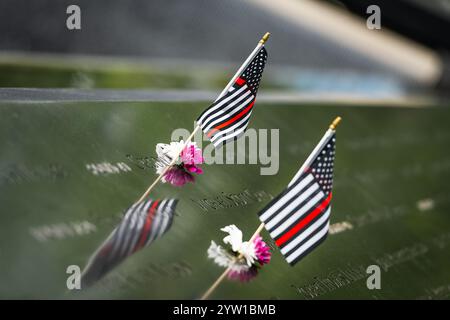 NEW YORK CITY - 18 MAI 2024 : drapeaux et fleurs américains placés au Mémorial de 9/11 à Lower Manhattan, New York City, capturés avec une faible profondeur Banque D'Images