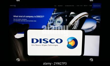 Allemagne. 19 juillet 2024. Dans cette illustration photo, une personne tient un téléphone portable avec le logo de la société japonaise d'outils de précision DISCO Corporation devant la page Web d'affaires. Crédit : SOPA images Limited/Alamy Live News Banque D'Images