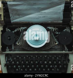 Une représentation artistique mettant en vedette une machine à écrire vintage élégamment ornée d'un plat décoratif placé sur le dessus Banque D'Images