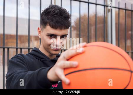 homme adolescent concentré tenant une balle de panier Banque D'Images