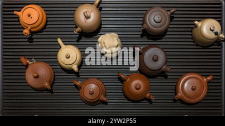 Une collection époustouflante de théières au design complexe qui mettent en valeur une variété de couleurs sur une surface élégante Banque D'Images