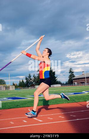 Voûte à perche féminine à mi-action lors d'une journée ensoleillée sur une piste athlétique Banque D'Images