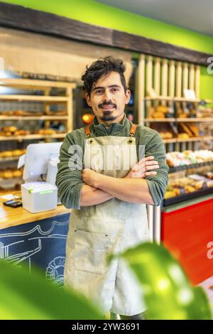 Portrait vertical d'un boulanger artisan masculin latin debout fier dans la boutique de nouvelles affaires Banque D'Images