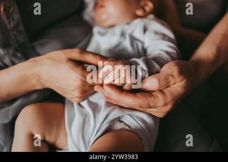 Maman et papa tenant la main de bébé Banque D'Images