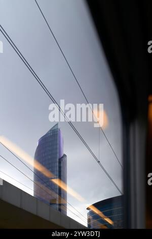 Gratte-ciel vu d'en bas contre un ciel nuageux, avec des lignes architecturales et des câbles croisant le cadre, Bruxelles, Belgique Banque D'Images