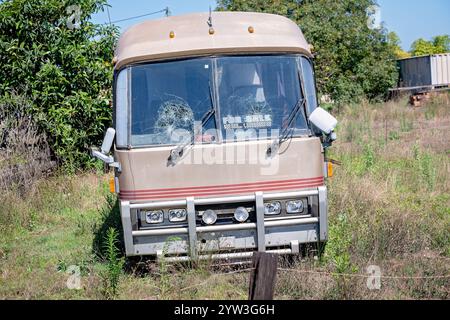 Épave de bus cassée abandonnée, à vendre, désertée dans le paddock de cour, pare-brise en verre brisé Banque D'Images